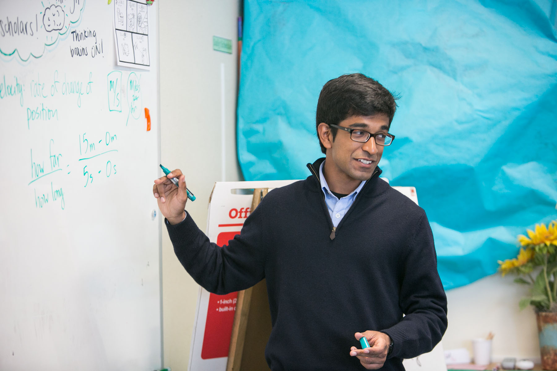 Dinesh Ayyappan teaching students in a classroom setting, demonstrating hands-on learning activities